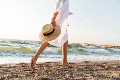 Nutrition plans tailored to client needs. Woman strolling along a beach.